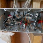 Detailed view of an open electrical switchboard with tangled wires and cables.